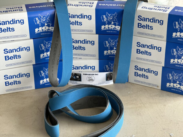 1 X 30" HOG BRAND "J" WEIGHT FLEXIBLE BLUE CERAMIC SANDING BELTS, 12 PACK displayed with boxes.