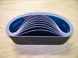 3 X 24" HOG BRAND SILICON CARBIDE SANDING BELTS, 8 PACK stacked for industrial use